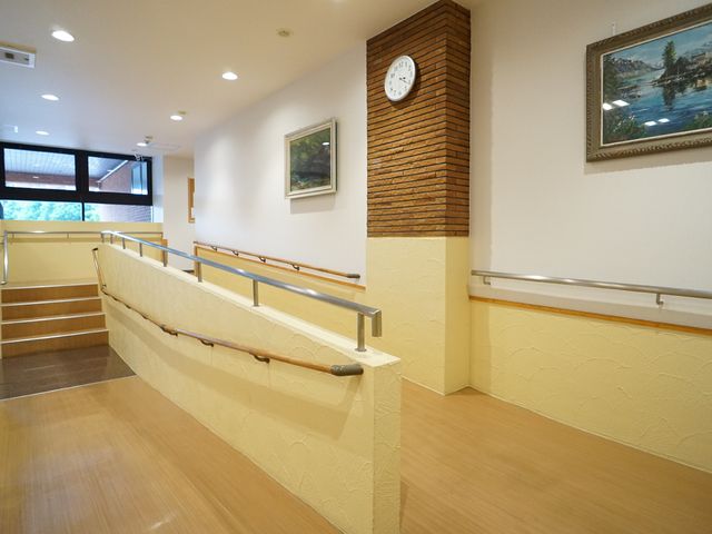 広々とした廊下の風景 エントランス 手すり完備の温かみを感じる廊下です。明るく開放的な空間で、移動も安全に行えます。