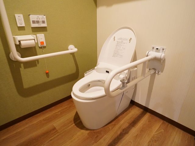 バリアフリー設計のトイレ トイレ 手すりが設置された清潔なトイレです。安全かつ自立した利用が支援される環境が整っております。