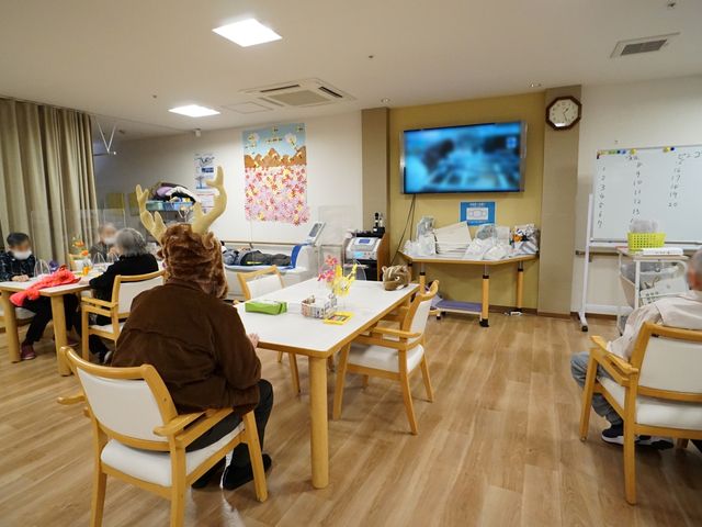 共用ラウンジの活動風景 共有スペース 複数の利用者が様々な活動を楽しむ椅子と机のあるラウンジです。共有空間での交流があたたかい雰囲気を醸し出しています。