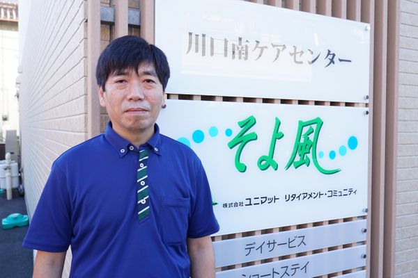 笑顔のスタッフと看板