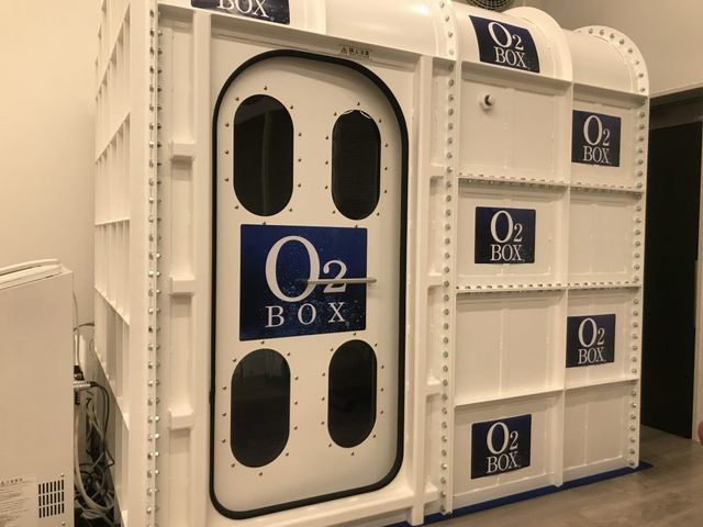 O2BOXの設置室 内観   白を基調とした空間に、O2BOXが設置されています。機器のある環境で、健康管理に配慮した取り組みがうかがえます。