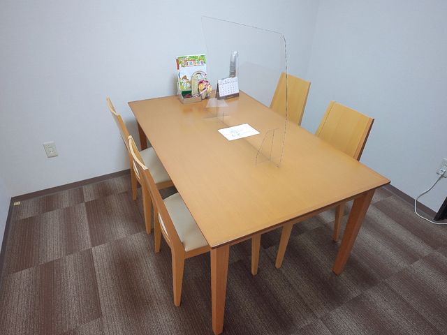 シンプルな会議室のテーブル 相談室 ゆったりとした木製テーブルが中心の部屋では、打ち合わせや静かな読書時間も過ごせます。シンプルなデザインで、どなたも使いやすい環境が整っています。