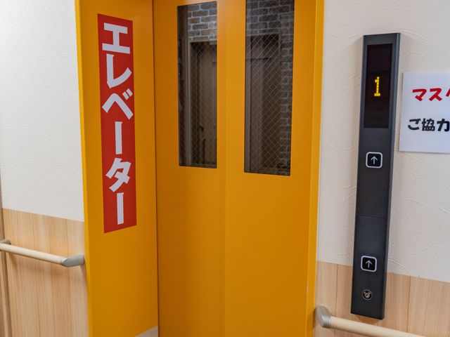 安全な移動手段エレベーター エレベーター 明るいオレンジ色の扉が視認性の高いエレベーターです。各フロア間の移動がスムーズに行えます。