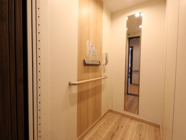 手すり付き廊下の角 エレベーター 手すりが付いた廊下の角です。スムーズに移動できるよう配慮された設計になっており、安心してご勤務いただけます。