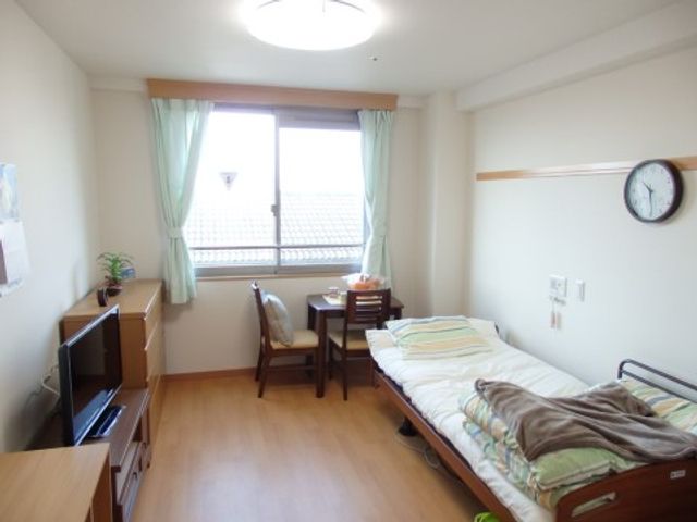 明るい個室の居住空間 居室 ゆったりとした居室は、必要な家具が整っており、窓からは自然光が差し込んでいます。安心して生活ができるように配慮された空間です。