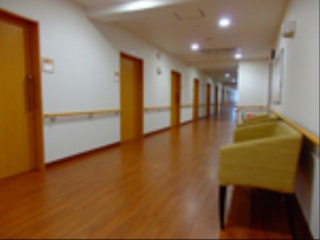 明るく広々とした廊下 廊下 手すりが備えられ、清潔感のある廊下はゆったりとしており、心地よい移動ができそうです。ゆとりある通路は働く環境への配慮が感じられます。