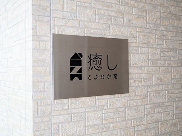 施設の名前の看板 外観 清潔感のある壁に掲げられた品格を感じさせる看板。働く場としての第一印象が際立つデザインです。