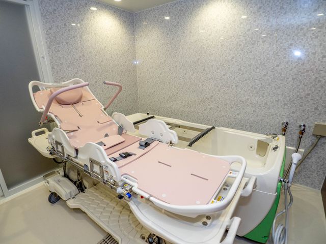 バリアフリー設計の浴室 機械浴槽 ユニットバスが備えられた清潔感溢れる空間です。利用者の安全と快適さを考慮した設備が整っており、安心してご利用いただけます。