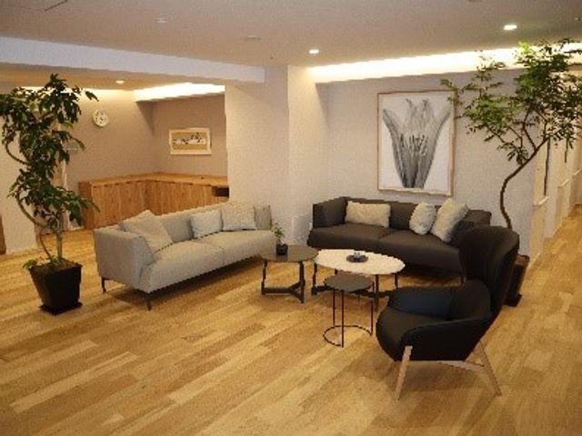 快適な共有スペース 1階リビングラウンジ ソファがそろった心地よい休憩所で、利用者の憩いの場を実感していただけます。木目調の床と暖かい光が、落ち着いた雰囲気を演出しています。