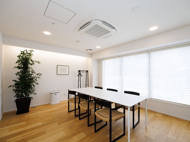 白い壁と木の床の会議室 プラチナラウンジ 落ち着いた色合いの清潔感のある室内です。窓からの自然光で心地よい環境が保たれています。