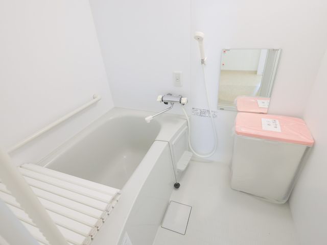 清潔な浴室 浴室 白を基調とした清潔感あふれる空間です。手すりが設置され、安全に配慮されています。