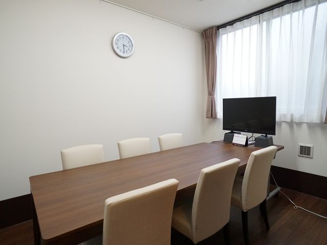 会議室のテーブルと椅子 共有スペース 落ち着いた色合いの多目的室で、多彩な活動が行える快適なスペースです。主に会議やレクリエーションに利用されています。
