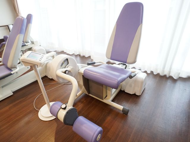 リハビリ機器が並ぶ部屋 共有スペース 床の木目と調和したリハビリ機器が設置された空間です。お体のケアをしながら心地よい時間を過ごすことができます。