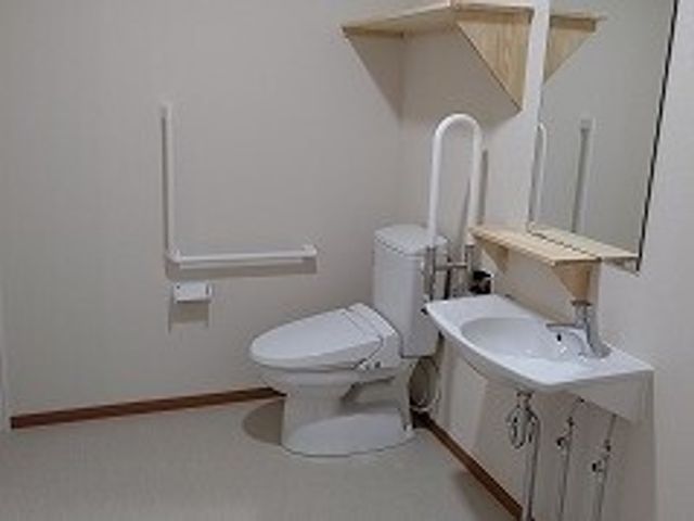 バリアフリー対応の洗面所 トイレ 手すりが取り付けられた清潔なトイレです。自立支援を重視した設計になっており、安全で快適な日々を送れます。