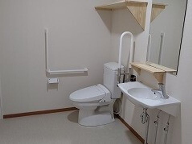 バリアフリー対応の洗面所 トイレ 手すりが取り付けられた清潔なトイレです。自立支援を重視した設計になっており、安全で快適な日々を送れます。