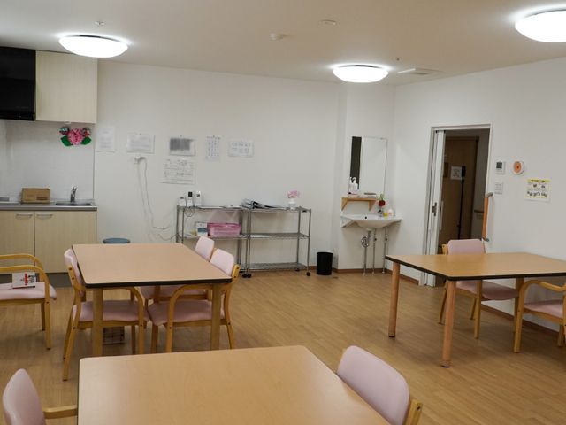 居室の広々した空間 共有スペース ゆったりとした居室では、入居者の方々が共に食事などを楽しまれ、交流が生まれる設計になっています。明るい色使いで心地よい時間をお過ごしいただけます。
