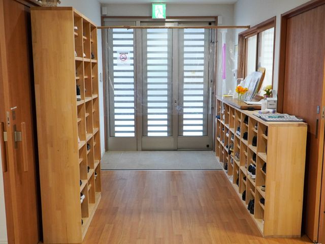 明るい玄関ロビー 玄関 清潔感溢れるエントランスが、来訪者を温かく迎え入れます。花が飾られ、心地よい空間でのお出迎えができる環境です。