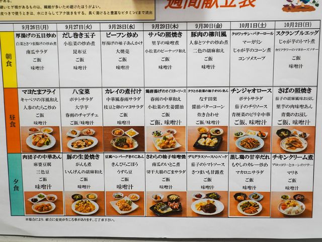 週間メニュー表 献立表 バランスの取れた毎日の食事メニューが、見やすい表で掲示されています。栄養満点で、色とりどりの食事が用意されている様子が伺えます。