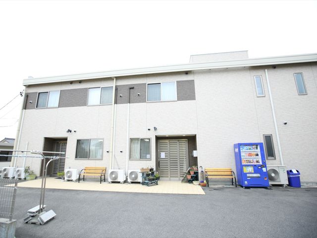 清潔な建物の外観 外観 落ち着いた色合いの建物です。ベンチが設置された開放的なスペースがあり、外の空気を感じられる環境が整っています。