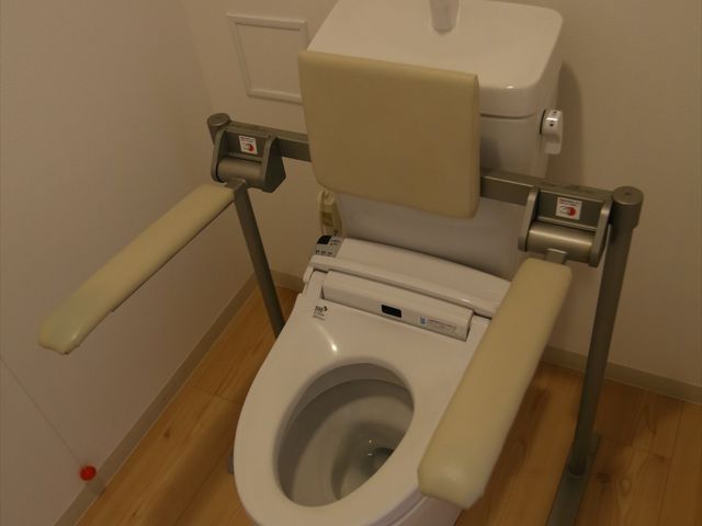 バリアフリートイレ トイレ 支持手すり付きのトイレで、利用者の安全と自立支援を考えた設計です。清潔で利便性の高い環境が整っています。