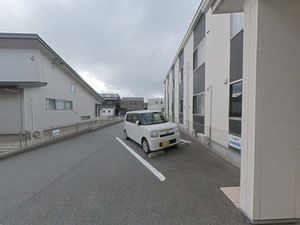 白い壁の建物と駐車場