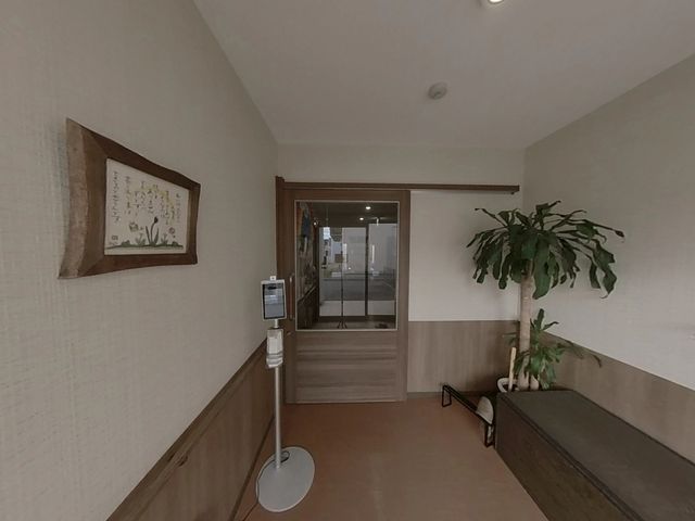 ゆったり待合スペース ロビー 広々とした待合スペースには、壁面の掲示物や観葉植物が配置され、落ち着いた雰囲気です。