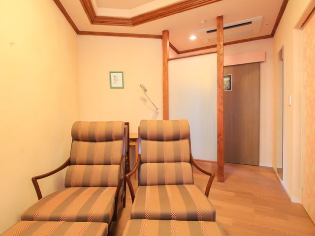ゆったりした椅子のある廊下 椅子 木目調のあたたかみのある廊下には、くつろげる椅子が配置され、待合スペースとしての機能も備えています。ここで一息つきながら、落ち着いた時間を過ごすことができます。