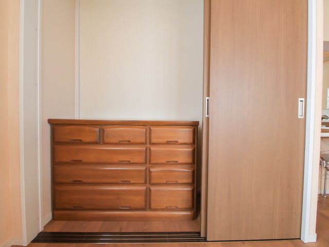 木製のたんすと扉 クローゼット 落ち着いた色合いの居室で、木製のたんすが備え付けられており、入居者様の快適な生活空間が確保されています。