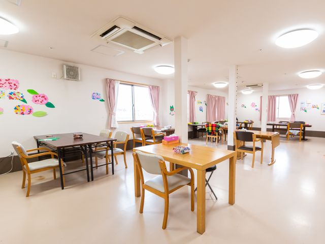 暖かい雰囲気の共有スペース 食堂 開放感のある広々とした多目的室です。壁に飾られた花のアートが鮮やかで、ここでのひとときを心地よく過ごせそうです。