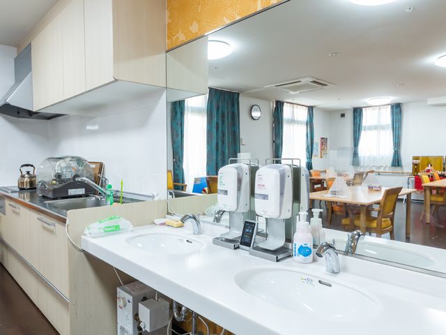 清潔なキッチンカウンター 洗面台 ゆったりとした食事スペースが設けられ、日常の食事やコミュニケーションが楽しめる場所です。キッチンカウンターも整っており、快適な環境が整っています。