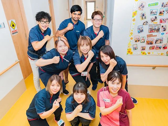 スタッフ集合の廊下 廊下   明るい廊下で、スタッフの皆さんが笑顔で並んでいます。働く仲間の雰囲気が伝わり、職場の様子をイメージしやすいです。