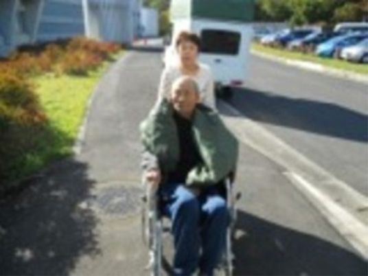 車椅子の高齢者と介助者