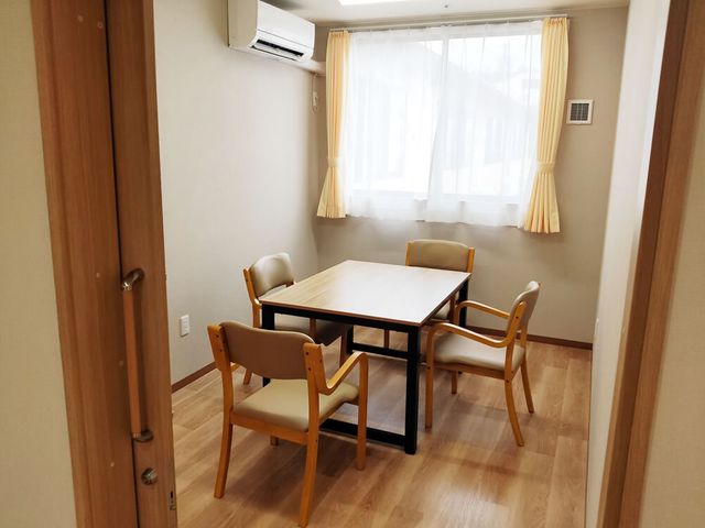 明るく清潔な居室 談話室 ゆったりとした空間の居室で、穏やかな日差しが降り注ぐ窓際にはダイニングテーブルが設置されています。安らぎの一時を、ここで過ごしてみませんか。