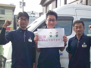 スタッフが看板を持つ外観  