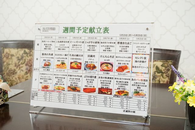 献立表と花 食事 彩り豊かな料理を毎日提供する食堂の献立表です。バランスの良い食事で、利用者様の健康を支えます。