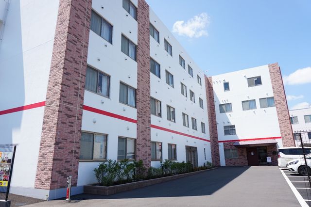 清潔感のある施設の外観 外観 鮮やかな空の下、清潔で整った建物が印象的です。働く環境としても快適そうな雰囲気が感じられます。