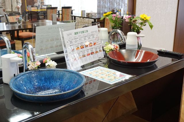 カラフルな洗面台のカウンター 洗面台 配色が明るく心地よい空間の食堂には、手洗いのための洗面台も備え付けられており、衛生管理に配慮されています。