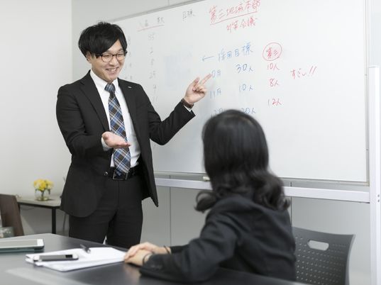 会議室で説明する男性