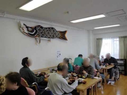 飾り鯉と共に食事する人々