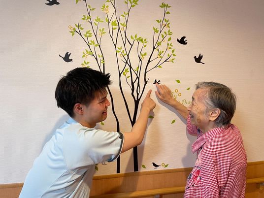 掲示物の鳥を指さす入居者