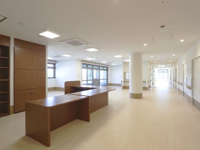 明るい廊下とデスク 廊下 自然光が差し込む明るい廊下には、広々としたデスクが配置されています。開放的で働きやすい環境です。