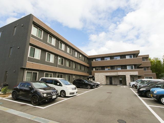 現代的な建物の外観 外観 広々とした駐車場があり、落ち着いた色合いで設計されたモダンな外観が特徴です。安心感があり、新しい職場として魅力を感じる方も多いでしょう。