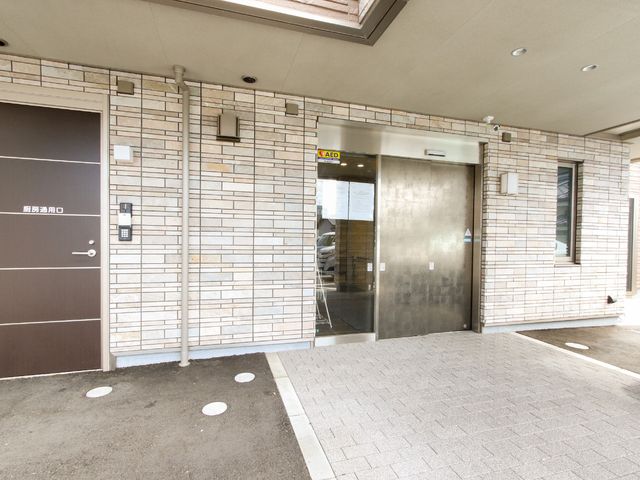 エントランスの建物正面 玄関 明るく清潔感のあるエントランスです。セキュリティシステムが備わっており、安心して勤務できる環境が整っています。