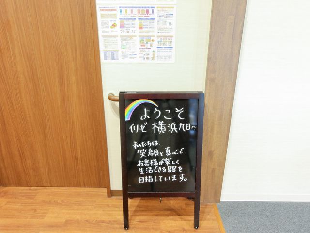 掲示物と案内看板 スタッフ 心温まるメッセージが書かれた案内板が、訪れる方を優しく迎え入れています。壁面は情報掲示板で整然と構成され、清潔感溢れる環境です。