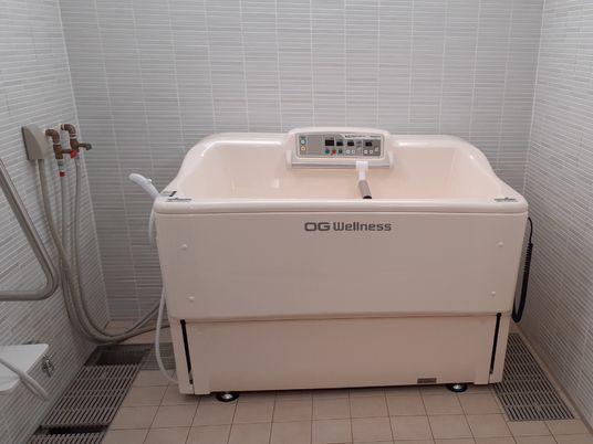 大手メーカーの機械浴設備を完備したタイル張りの浴室スペース