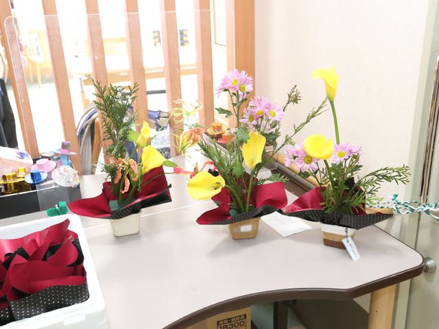 花飾りのある室内空間 レクリエーション 色鮮やかな花がテーブルを彩り、リラックスできるひと時を提供しています。日々のコミュニケーションの場を美しく演出しております。