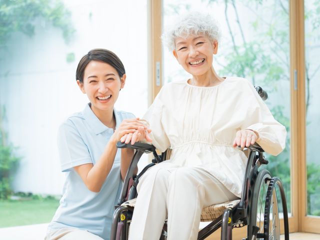 血圧計測をする施設の様子 スタッフ スタッフが血圧を計る様子は心温まる光景です。居心地の良い環境で、利用者の方々の健康管理をサポートしています。