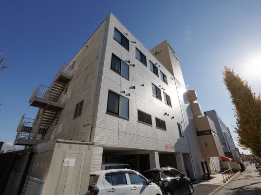 駐車場とスロープが設置してある介護施設の外観