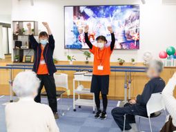 笑顔のスタッフと利用者の体操