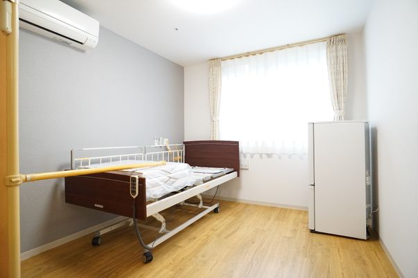 居室のベッドと冷蔵庫